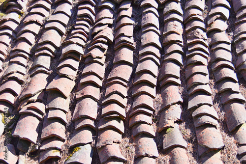 Irregular and broken roof tiles of an old abandoned building © Basurde