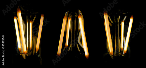 abstract background lighting bulbs. Lighting lamps on a black backdrop panorama. pattern for design. electric lighting concept