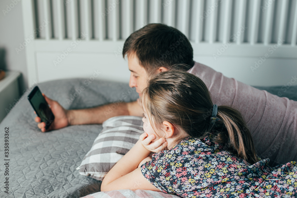Young father with daughter talking via video chat with grandmother. Family using phone for communication in quarantine. Stay home, self isolation, stay safe Young father with daughter talking via video chat with grandmother. Family using phone for communication in quarantine. Stay home, self isolation, stay safe