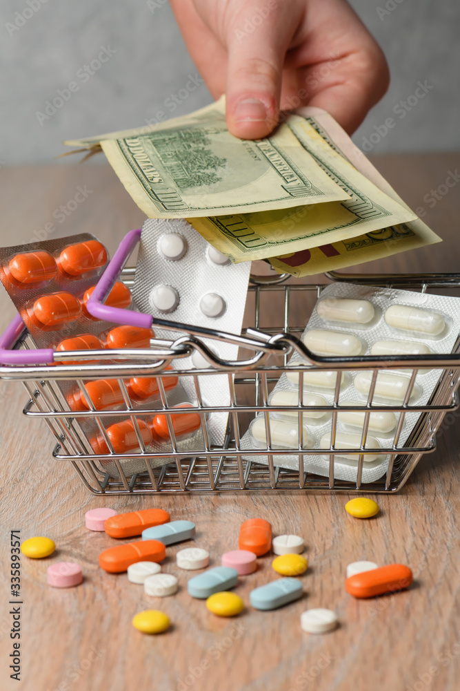 Packaging of medical tablets in the shopping cart. Scattered pills and money. The concept of buying pills. Protection and treatment from the virus.