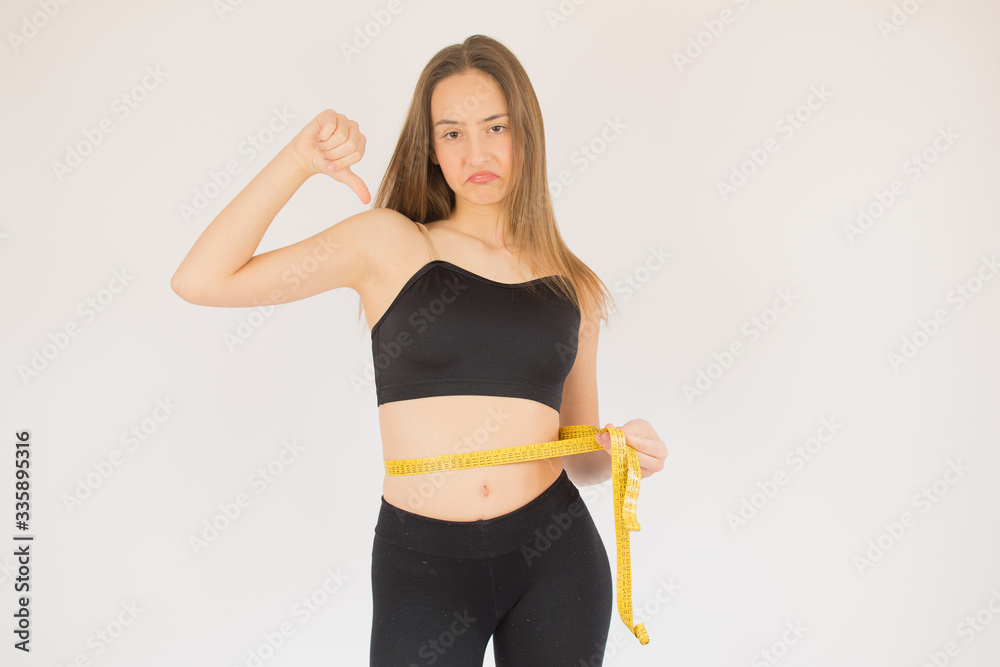 Beautiful fitness girl measuring her waist Beautiful fitness girl measuring her waist