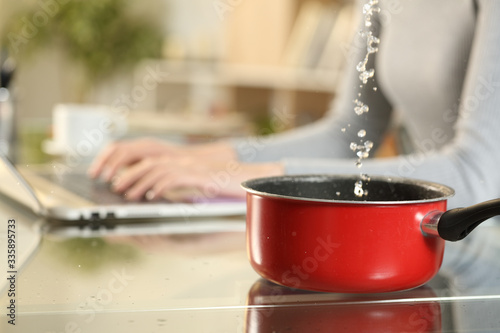 Woman hands typing on laptop suffering water leaks on foreground