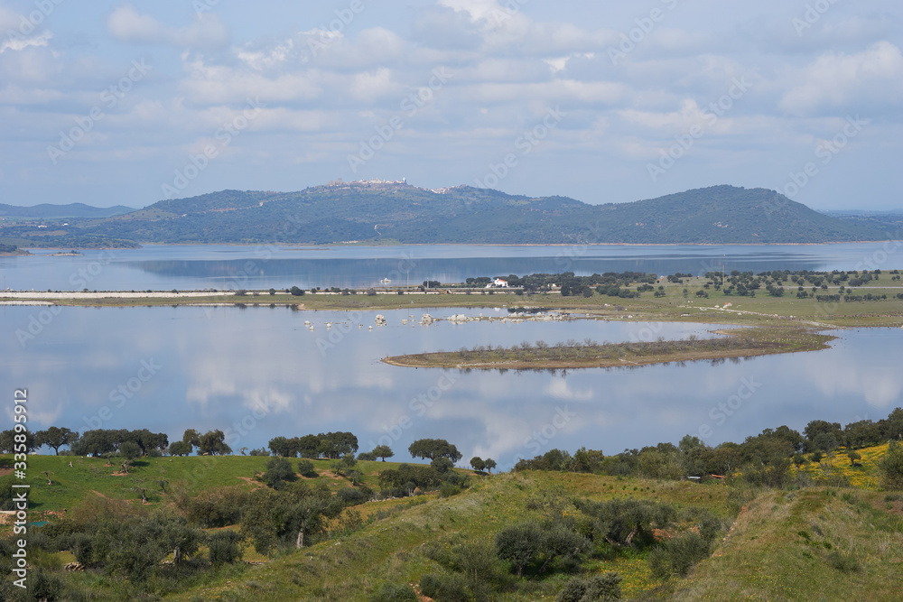 Lake reservoir water reflection of Alqueva Dam landscape and Monsaraz on the foreground in Alentejo, Portugal