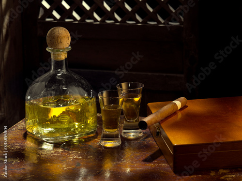 Canvas Print Close up view of bottle of tequila anejo and cigar on color background