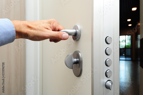 Obraz na płótnie security door - hand close and open the door - security against theft in the apartment - entry and exit - real estate w salonie