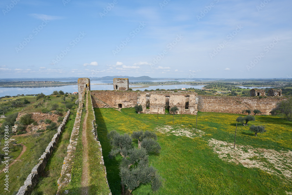 Fototapeta premium Mourao castle towers and wall historic building with alqueva dam reservoir in Alentejo, Portugal