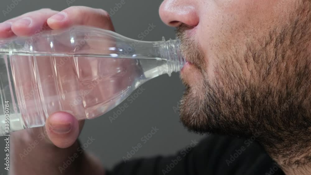 man drinks water from a plastic bottle Close up. man drinks water from a plastic bottle Close up.