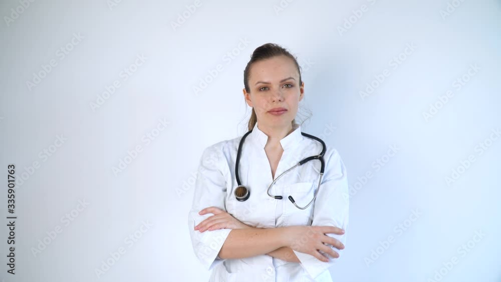 Portrait of a young woman doctor in a white coat with a stethoscope on a white background in a hospital Portrait of a young woman doctor in a white coat with a stethoscope on a white background in a hospital