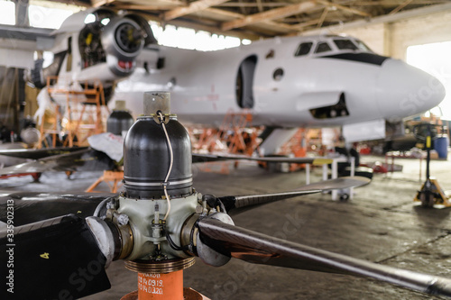 Repair of an AN-26 cargo plane in a hangar. Screw in the foreground