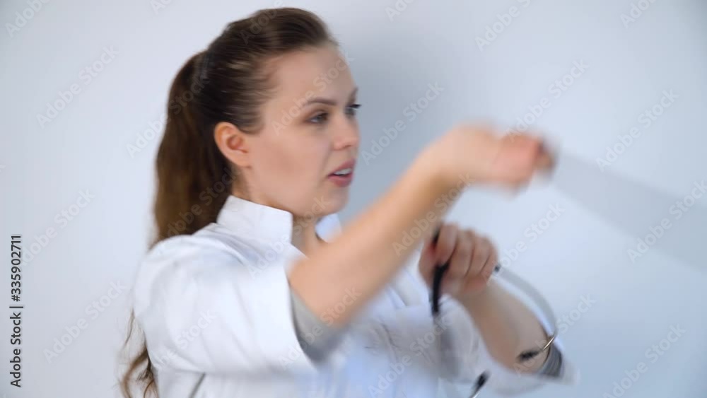 Funny doctor woman throws a stethoscope on a white background in a hospital Funny doctor woman throws a stethoscope on a white background in a hospital