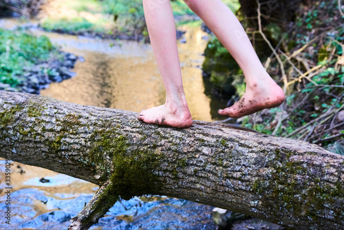 Child girl feet walking on tree trunk. Selective focus © Petr Bonek