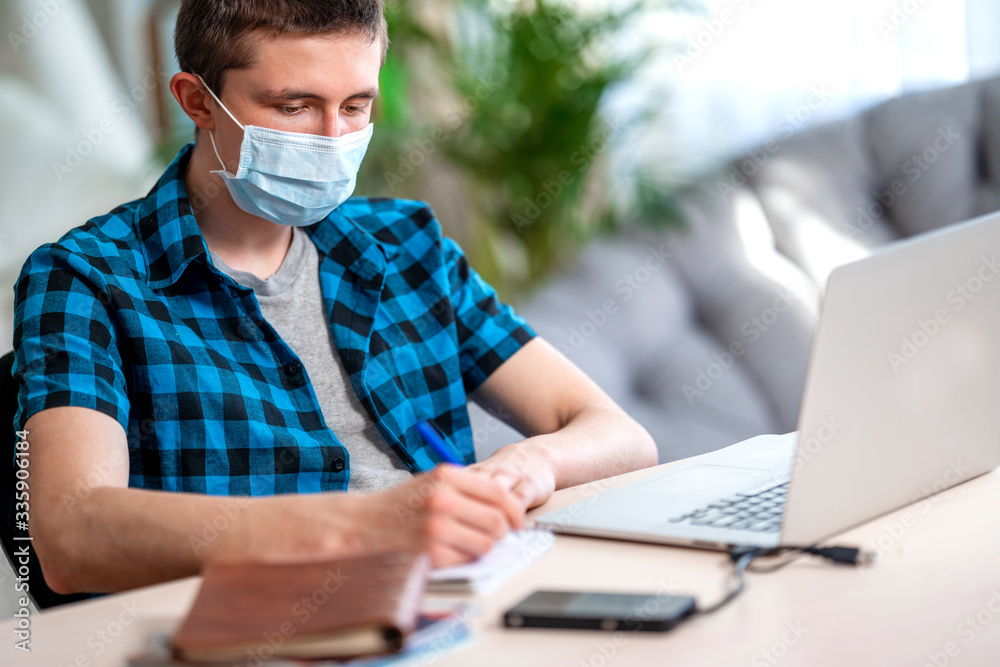 active teenager in mask and headphones with laptop during coronavirus quarantine active teenager in mask and headphones with laptop during coronavirus quarantine