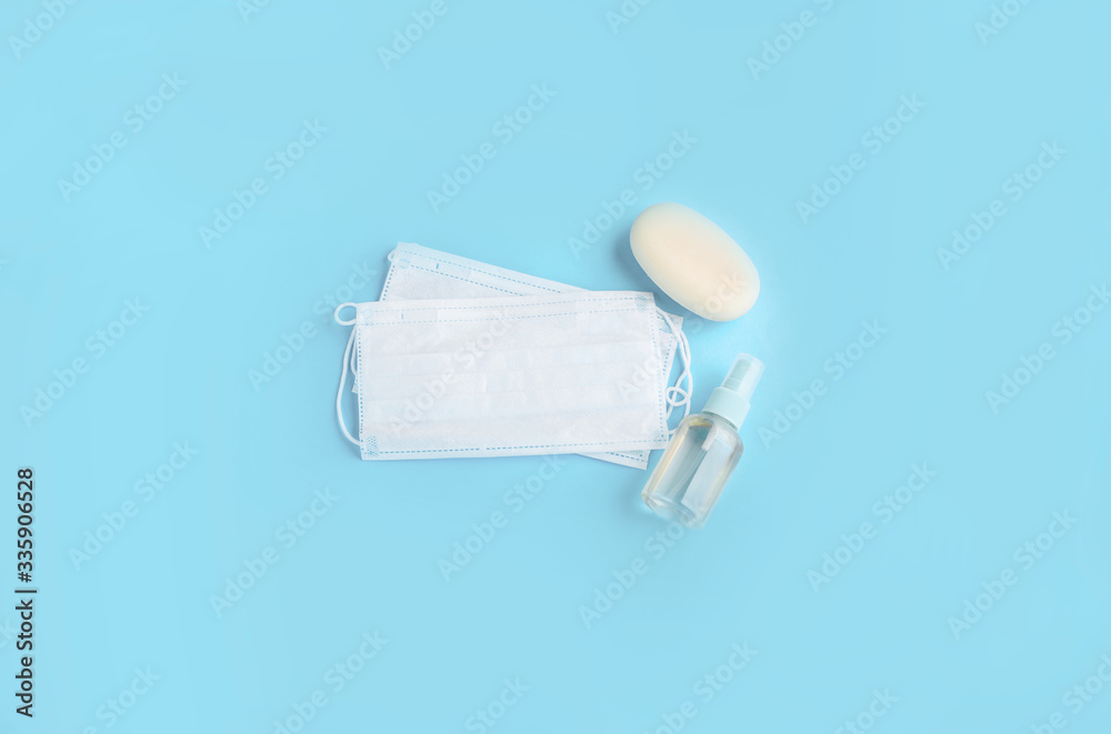Blue face mask with soap and hand antiseptic on a light background. Protection from the virus. Blue face mask with soap and hand antiseptic on a light background. Protection from the virus.