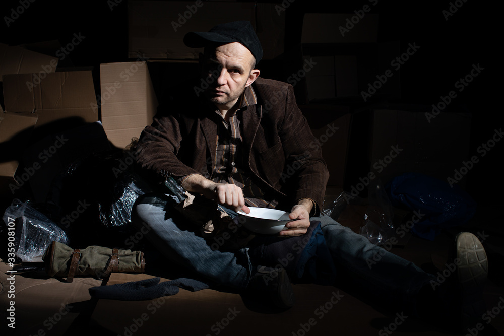 The homeless man managed to get food and begins to eat it. The homeless man managed to get food and begins to eat it.