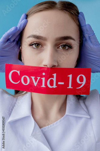 Doctor woman pointing to red paper with mesaage Coronavirus on blue background. World Health Organization WHO introduced new official name for Coronavirus disease named COVID-19 photo