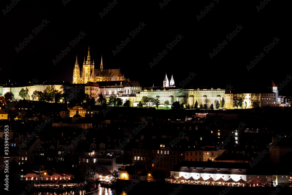 View of Prague Castle, St Vitus Cathedral and Mala Strana across the Vltava River, Prague, lit at night.
