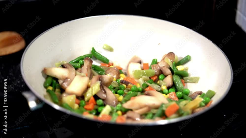 Preparation of vegetables in a pan. Mixing vegetables with wooden shoe. Preparation of vegetables in a pan. Mixing vegetables with wooden shoe.
