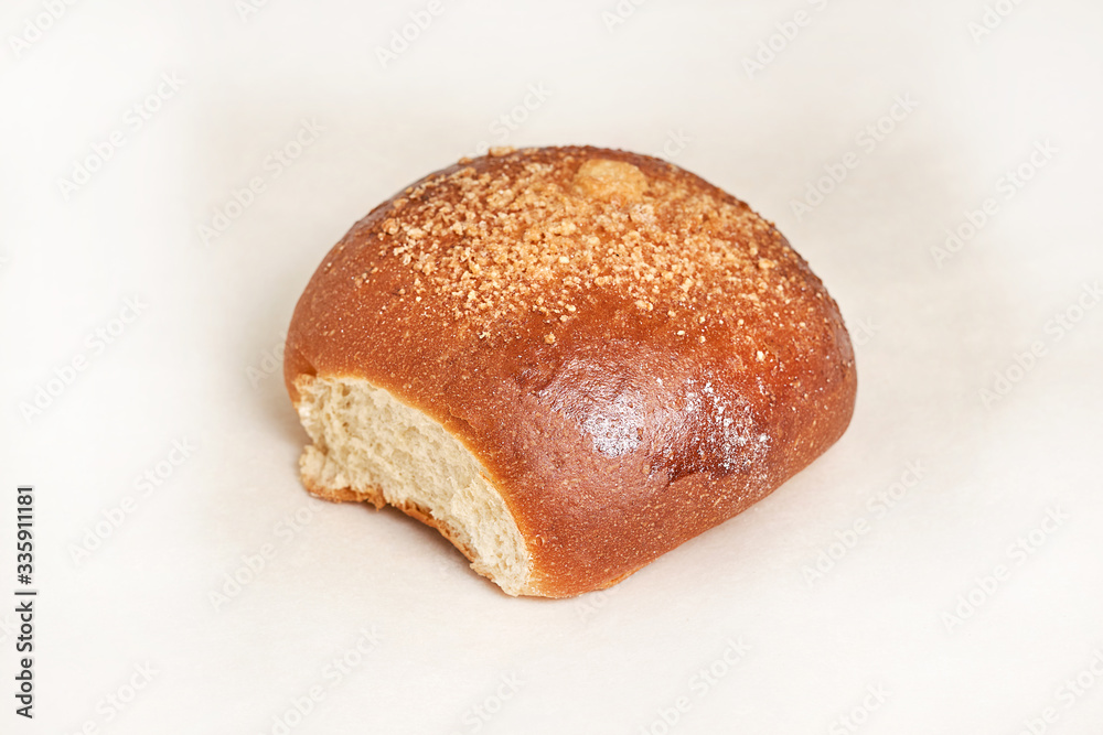 Fresh bread loaf sprinkled with grated walnut. Closeup on a light background Fresh bread loaf sprinkled with grated walnut. Closeup on a light background