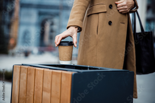 Female standing near a garbage can outdoors