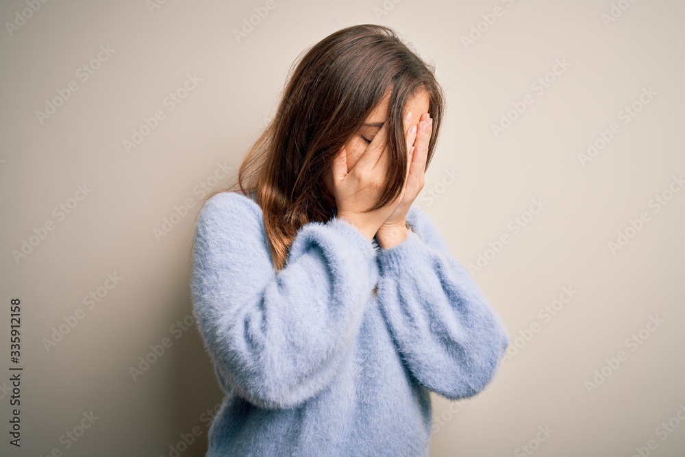 Beautiful young woman wearing casual winter sweater standing over isolated background with sad expression covering face with hands while crying. Depression concept. Beautiful young woman wearing casual winter sweater standing over isolated background with sad expression covering face with hands while crying. Depression concept.