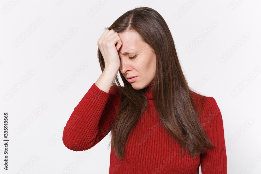 Tired upset young brunette woman girl in casual red clothes posing isolated on white background studio portrait. People lifestyle concept. Mock up copy space. Keeping eyes closed, put hand on head.