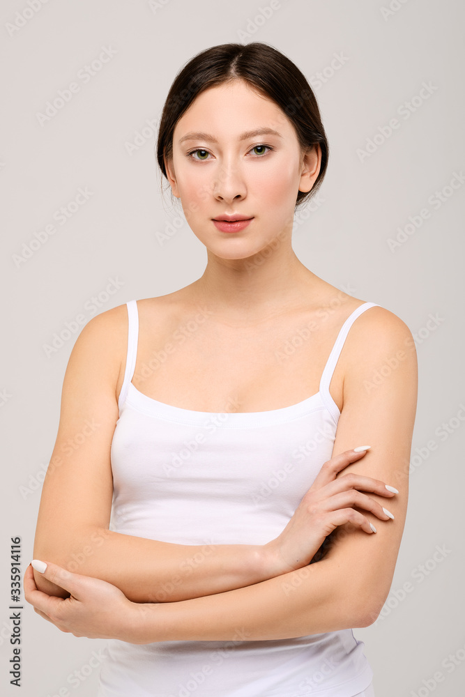 Portrait of beautiful happy asian girl with arms folded on the stomach Portrait of beautiful happy asian girl with arms folded on the stomach