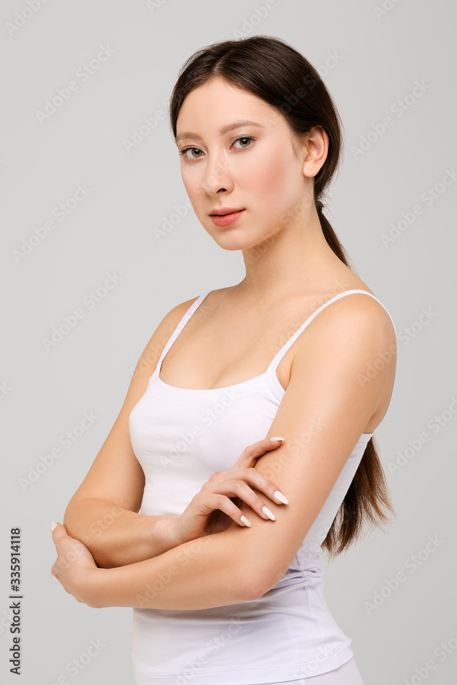 Portrait of beautiful happy asian girl with arms folded on the stomach Portrait of beautiful happy asian girl with arms folded on the stomach