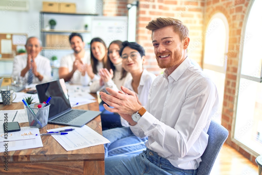 Group of business workers smiling happy and confident. Working together with smile on face looking at the camera applauding at the office Group of business workers smiling happy and confident. Working together with smile on face looking at the camera applauding at the office