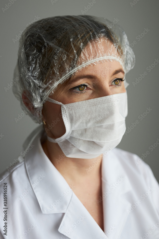 Doctor with face covered with mask. Portrait of young woman wearing the uniform and mask to avoid virus infection and to prevent the spread of disease. Real people, authentic situations Doctor with face covered with mask. Portrait of young woman wearing the uniform and mask to avoid virus infection and to prevent the spread of disease. Real people, authentic situations