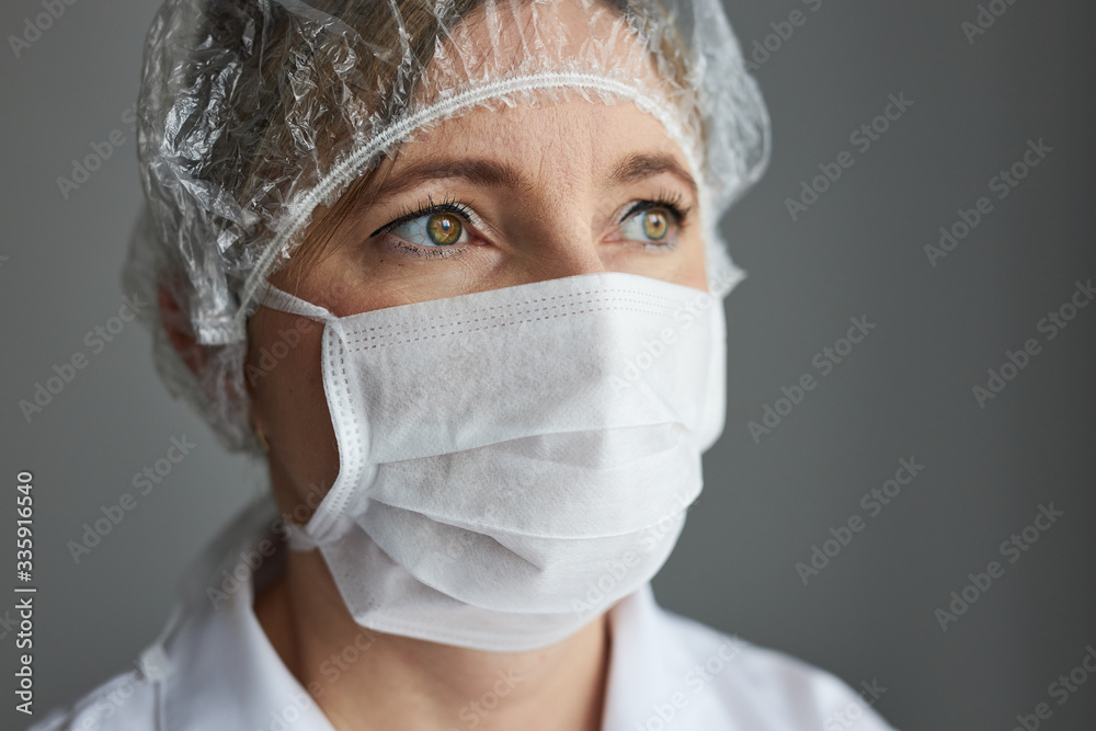 Doctor with face covered with mask. Portrait of young woman wearing the uniform and mask to avoid virus infection and to prevent the spread of disease. Real people, authentic situations Doctor with face covered with mask. Portrait of young woman wearing the uniform and mask to avoid virus infection and to prevent the spread of disease. Real people, authentic situations