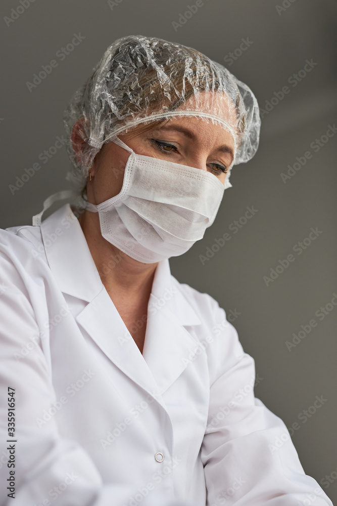 Doctor with face covered with mask. Portrait of young woman wearing the uniform and mask to avoid virus infection and to prevent the spread of disease. Real people, authentic situations Doctor with face covered with mask. Portrait of young woman wearing the uniform and mask to avoid virus infection and to prevent the spread of disease. Real people, authentic situations