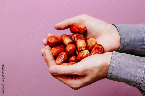 The guy holds in his hands dates (on a pink background). Ramadan