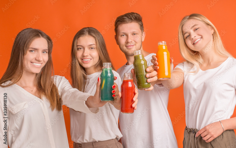 Company of teens celebrating with healthy detox drinks