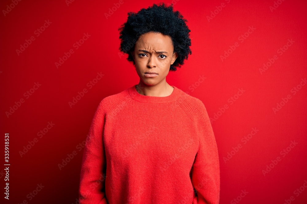 Young beautiful African American afro woman with curly hair wearing casual sweater skeptic and nervous, frowning upset because of problem. Negative person. Young beautiful African American afro woman with curly hair wearing casual sweater skeptic and nervous, frowning upset because of problem. Negative person.