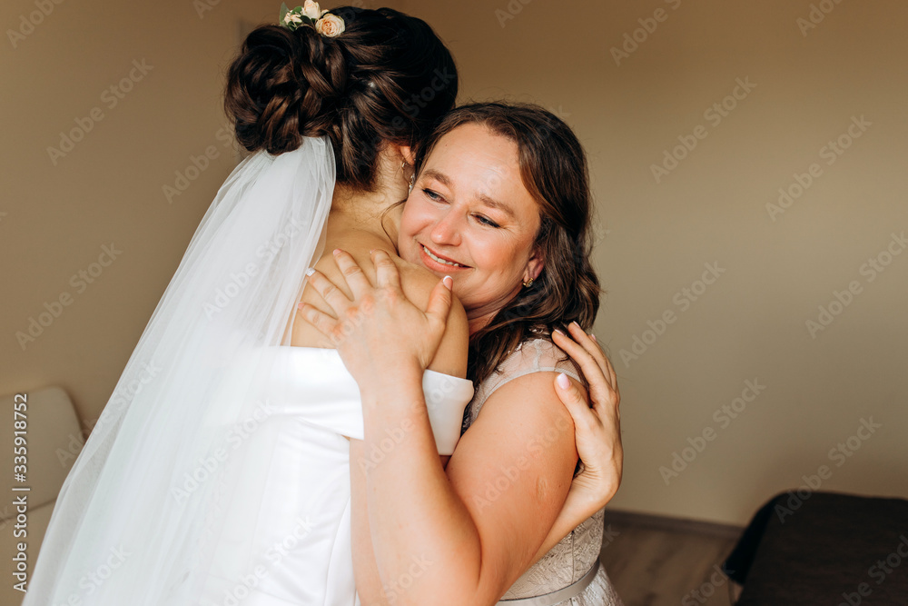 Sweet bride hugs her mom on her wedding day.