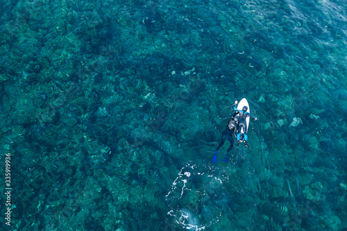 surfing instructor instructs you to ride the waves in the ocean top view shot from the air