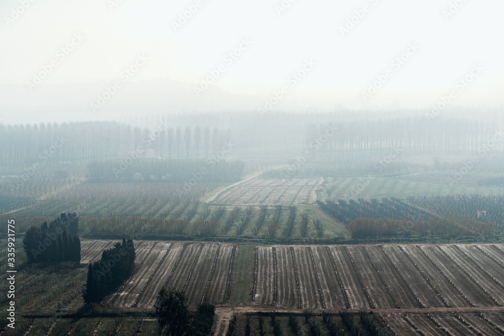 Scenic view of fields against hazy sky