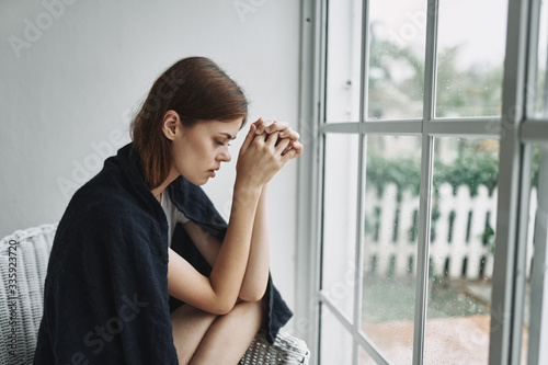 Free Download sad woman sitting on the window sill - GFXLoad