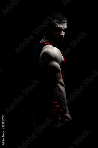 Muscular Man Flexing Muscles on Black Background