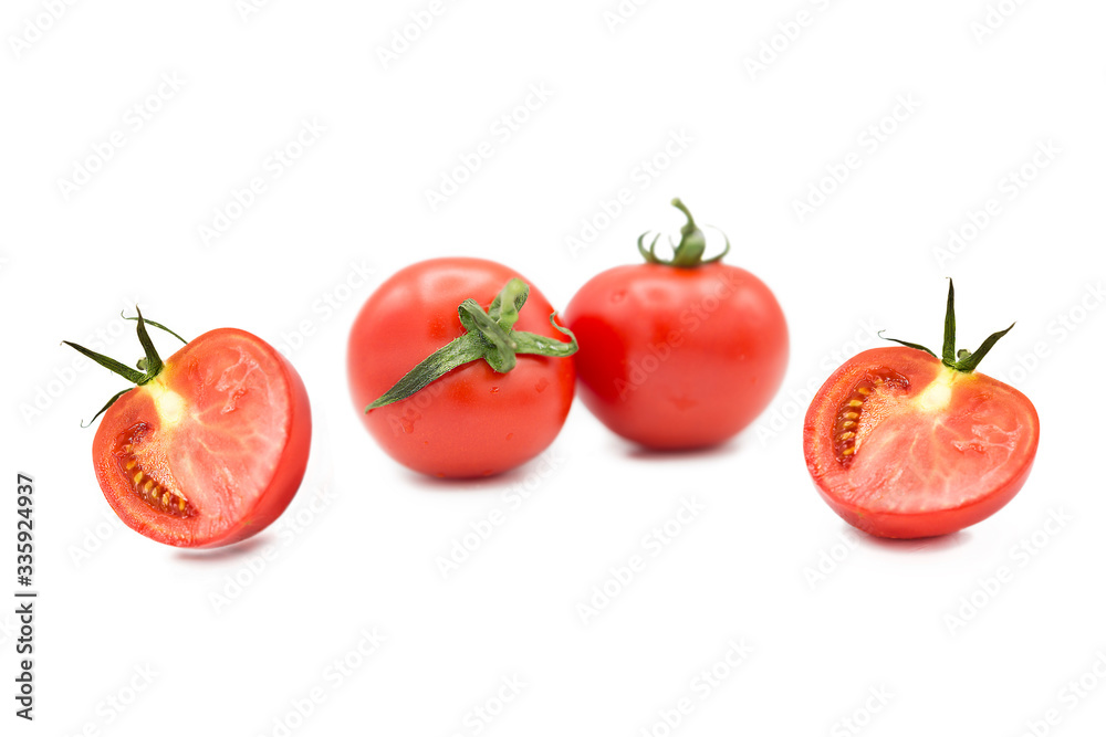 Ripe fresh organic tomatoes and two halves of a tomato in the drops of dew isolated on a white background Ripe fresh organic tomatoes and two halves of a tomato in the drops of dew isolated on a white background