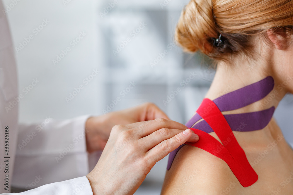 Kinesiology taping. Physical therapist applying kinesiology tape to