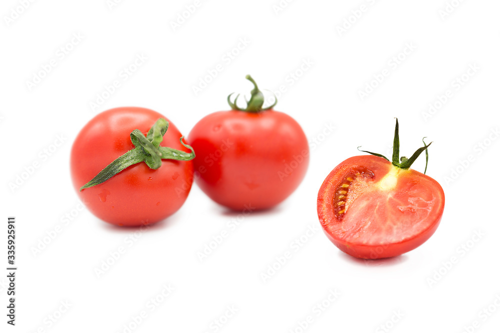Ripe fresh organic tomatoes and half a tomato in the drops of dew isolated on a white background Ripe fresh organic tomatoes and half a tomato in the drops of dew isolated on a white background