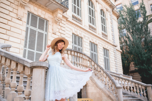 A young girl in a blue dress walks through the city of Barcelona