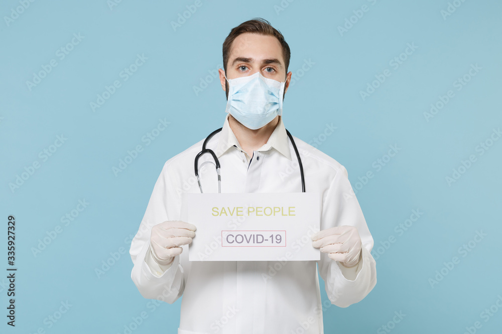 Male doctor man in medical gown face mask gloves isolated on blue background. Epidemic pandemic rapidly spreading coronavirus 2019-ncov sars covid-19 flu virus concept. Hold nameplate save people.