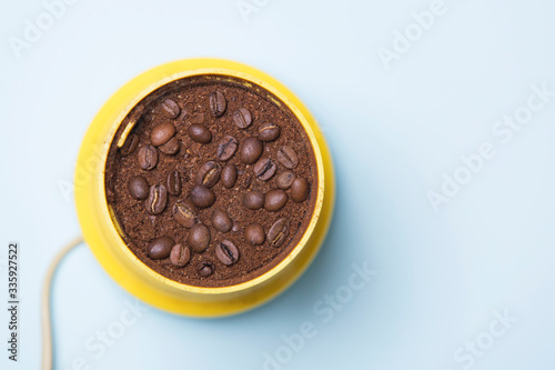 Yellow coffee grinder with coffee and beans  top view 