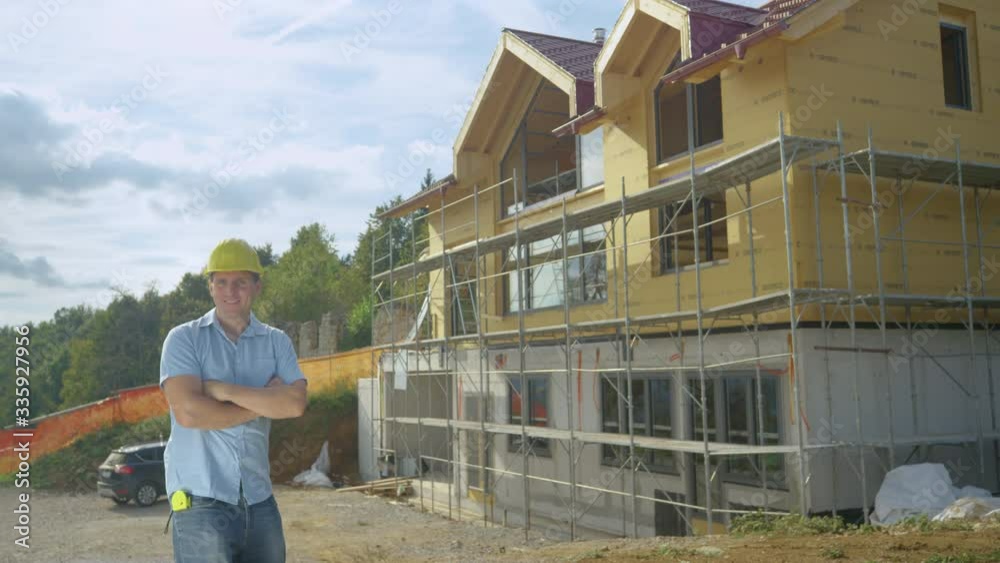 SLOW MOTION, COPY SPACE, CLOSE UP, PORTRAIT: Proud contractor throws his hard hat in air while standing in front of new house. Young Caucasian contractor is happy while building a big modern house. SLOW MOTION, COPY SPACE, CLOSE UP, PORTRAIT: Proud contractor throws his hard hat in air while standing in front of new house. Young Caucasian contractor is happy while building a big modern house.