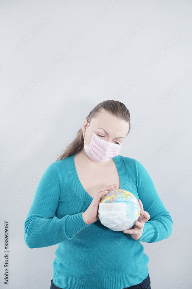 Global Flu Pandemic Concept. Arms with world globe With Medical Mask against covid-19 coronavirus on white studio background. Global Flu Pandemic Concept. Arms with world globe With Medical Mask against covid-19 coronavirus on white studio background.