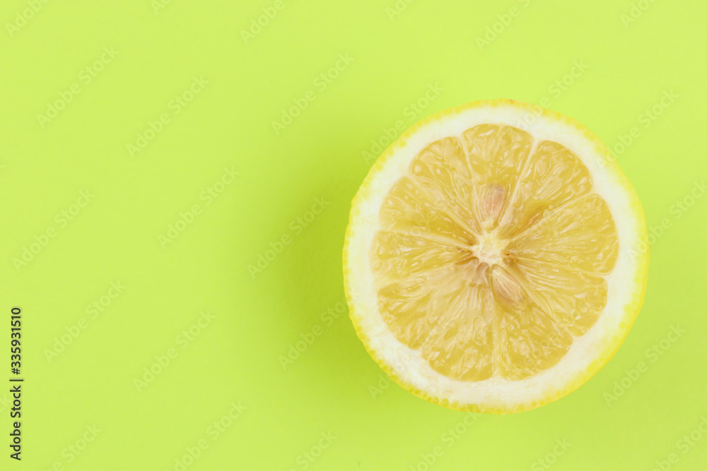 a circle, a slice of juicy lemon, yellow color lies on a bright green background. Freshness, detox, summer, vitamins, fresh, citrus, fruits a circle, a slice of juicy lemon, yellow color lies on a bright green background. Freshness, detox, summer, vitamins, fresh, citrus, fruits