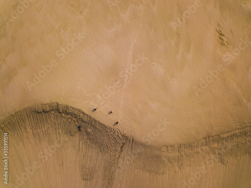 An aerial view of a sand dune in Northland, New Zealand which makes the people look like ants photo