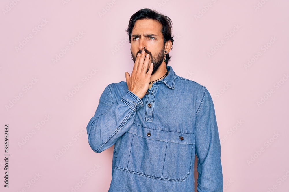 Young handsome hispanic bohemian man wearing hippie style over pink background bored yawning tired covering mouth with hand. Restless and sleepiness. Young handsome hispanic bohemian man wearing hippie style over pink background bored yawning tired covering mouth with hand. Restless and sleepiness.